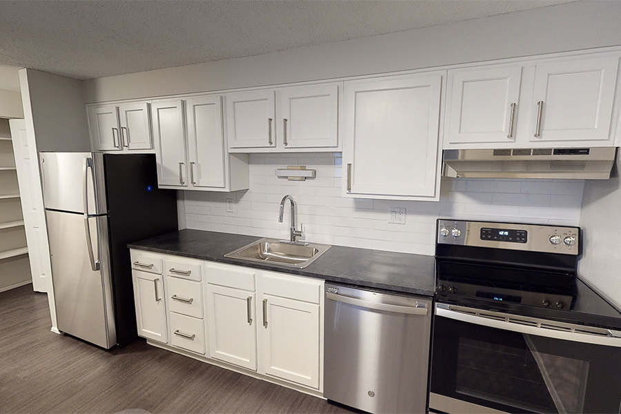 3D tour thumbnail showing kitchen with wood floor, white cabinets, and dark counter.