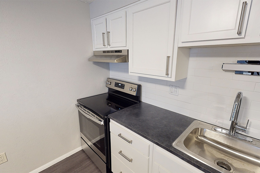 3D tour thumbnail showing kitchen with wood floors, white cabinets, and dark counters.