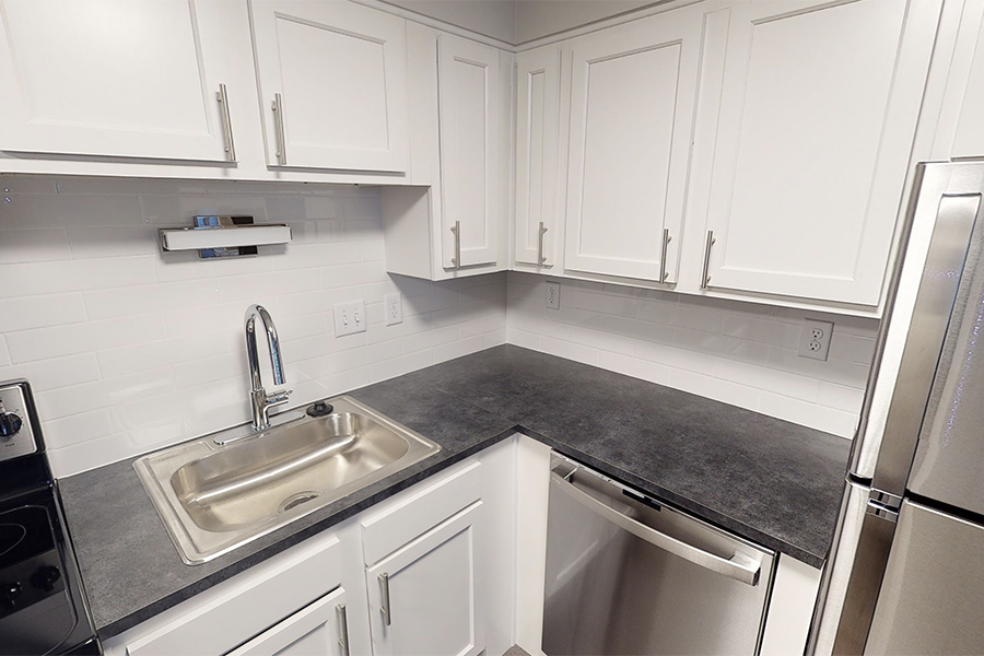 3D tour thumbnail showing kitchen with white cabinets, dark counters, and stainless sink.