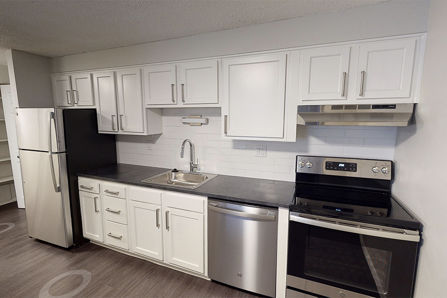 3D tour thumbnail showing kitchen with wood floor, white cabinets, and dark counters.