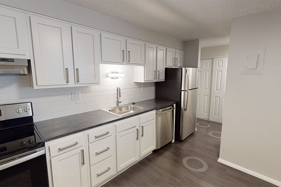 3D tour thumbnail showing kitchen with wood floor, white cabinets, and dark counters.