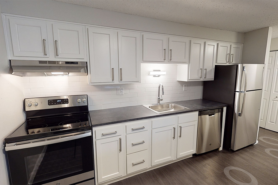 3D tour thumbnail showing kitchen with white cabinets, stainless appliances, and wood floor.