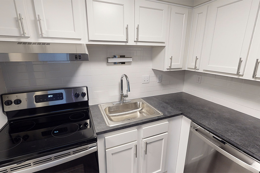 3D tour thumbnail showing kitchen with white cabinets, dark counters, and stainless sink.