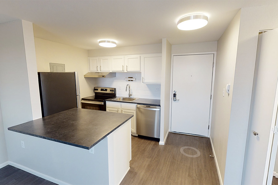 3D tour thumbnail showing kitchen with wood floors, large island counter, and white cabinets.