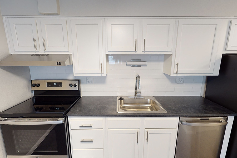 3D tour thumbnail showing kitchen with white cabinets, stainless appliances, and dark counters.