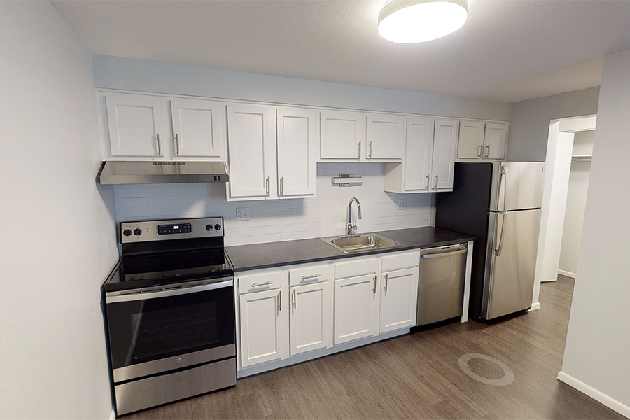 3D tour thumbnail showing kitchen with wood floor, white cabinets, and dark counters.