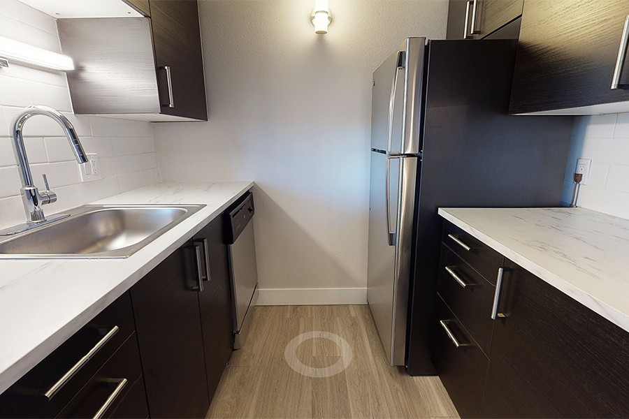 3D tour thumbnail for 1280 Lafayette showing kitchen with wood floor, dark cabinets, light counters, and stainless steel appliances.